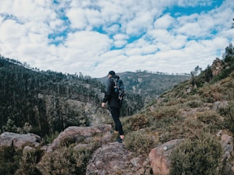 A scenic view of a hiker wearing a backpack in nature.