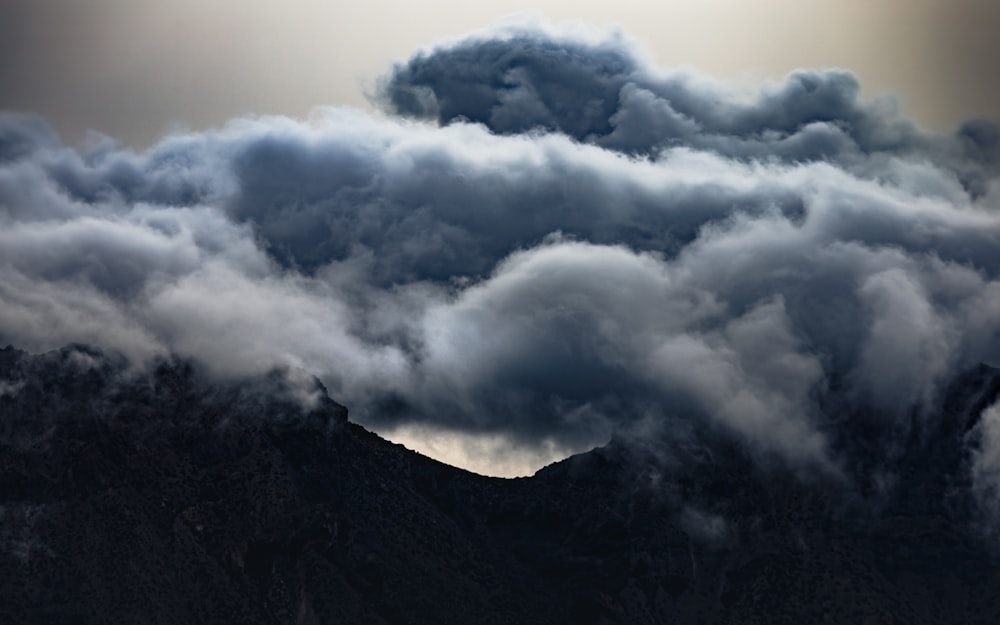 white clouds over mountain during daytime