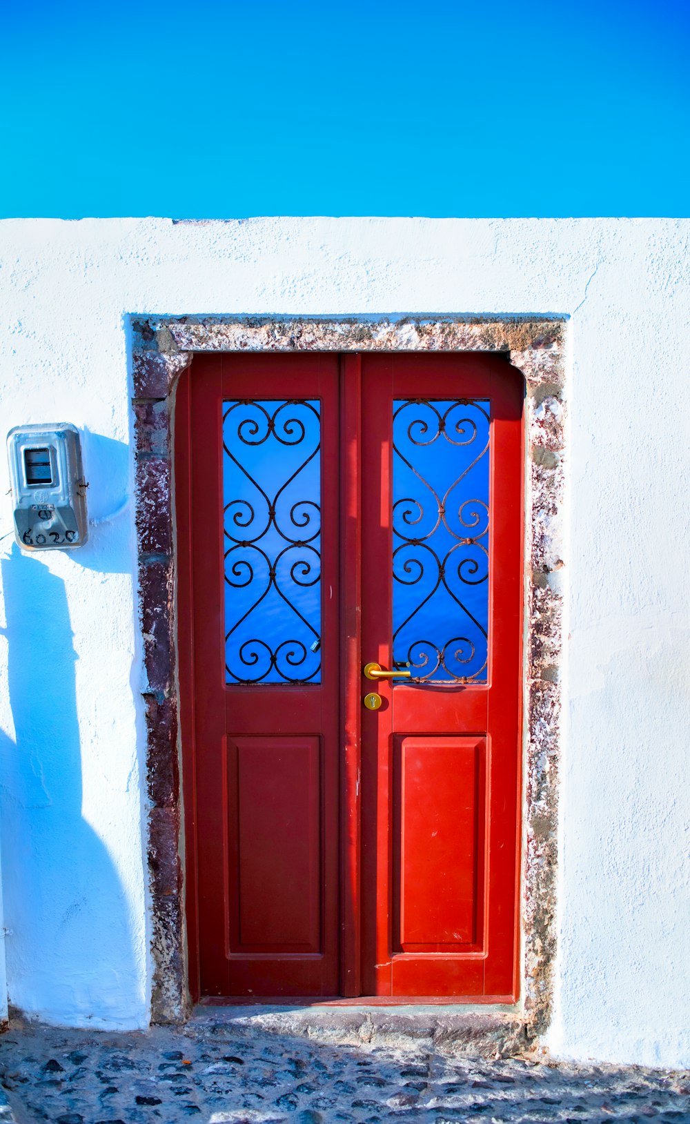 Puerta de madera azul con pared de hormigón blanco