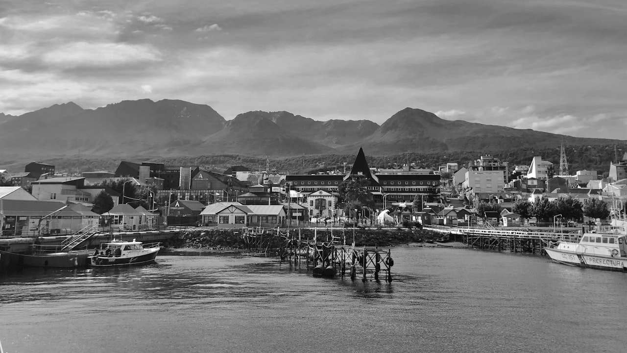 boats on dock near mountain during daytime in Ushuaia