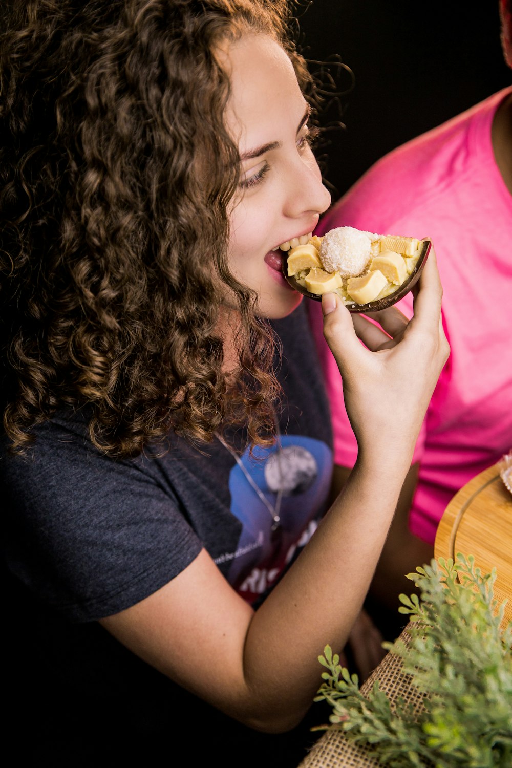 Chica con camisa negra comiendo hamburguesa