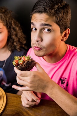 photography poses for dining,how to photograph boy in pink crew neck t-shirt holding chocolate cake
