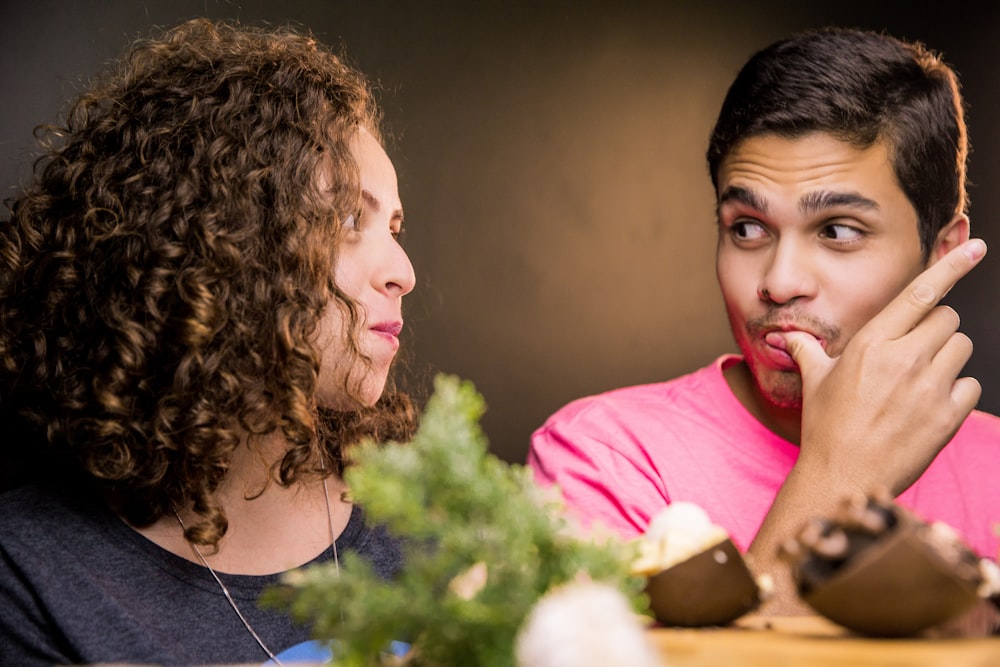 woman in pink crew neck shirt beside man in blue crew neck shirt