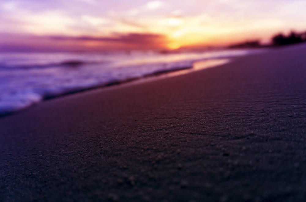 sea waves crashing on shore during sunset