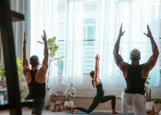 3 women doing yoga on blue yoga mat