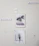 A wall with five pieces of art decor including a sign that says 'Be fearless', a picture of a pink van by palm trees, a sign that says 'Regret Nothing', a picture of an open book with flowers, and a small sign that says 'family forever'. The wall appears to have some tape or marks.