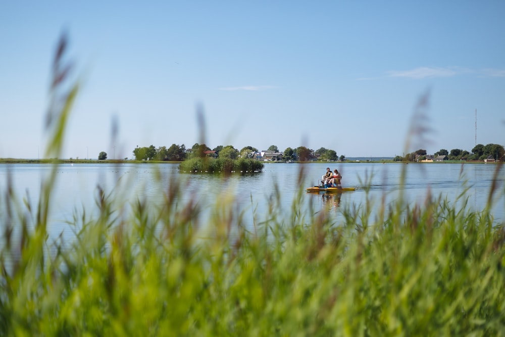 person in red shirt riding on boat on lake during daytime