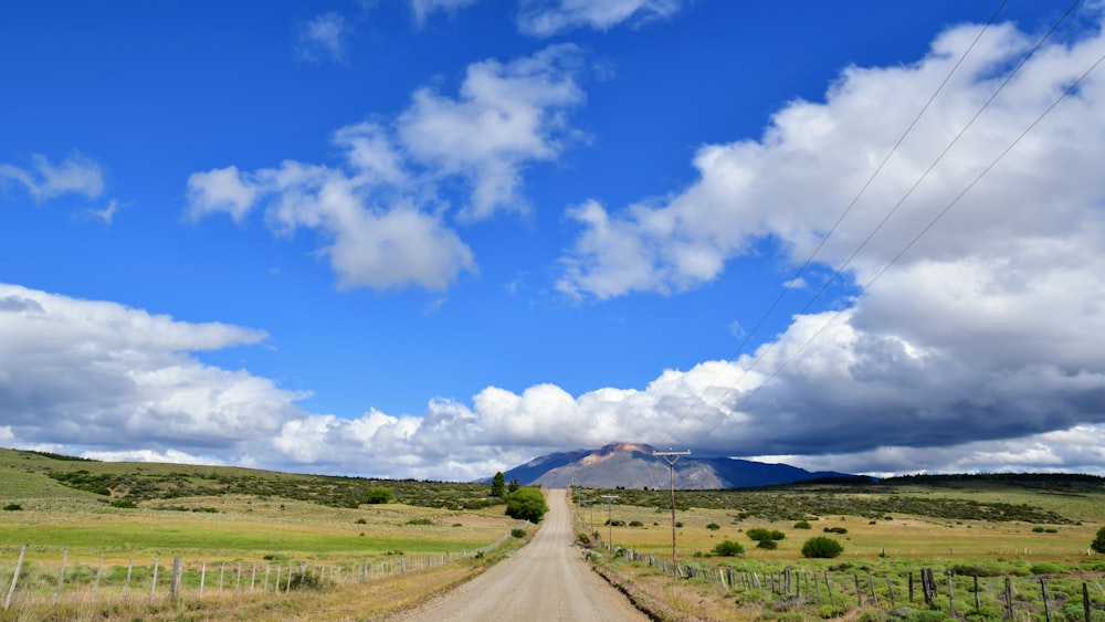 green grass field under blue sky and white clouds during daytime