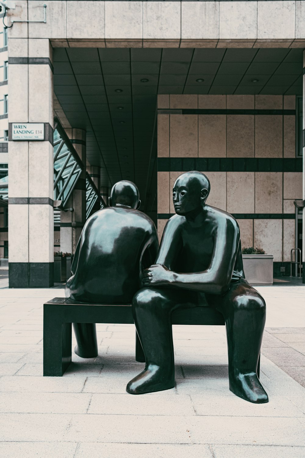 black statue of man sitting on bench