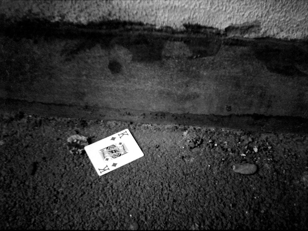 grayscale photo of identification card on concrete floor