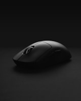 An ergonomic premium wireless mouse with smooth curves and a matte finish placed beside a laptop