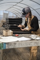 A technician assisting a farmer in filling out PSR application forms in a bright office.