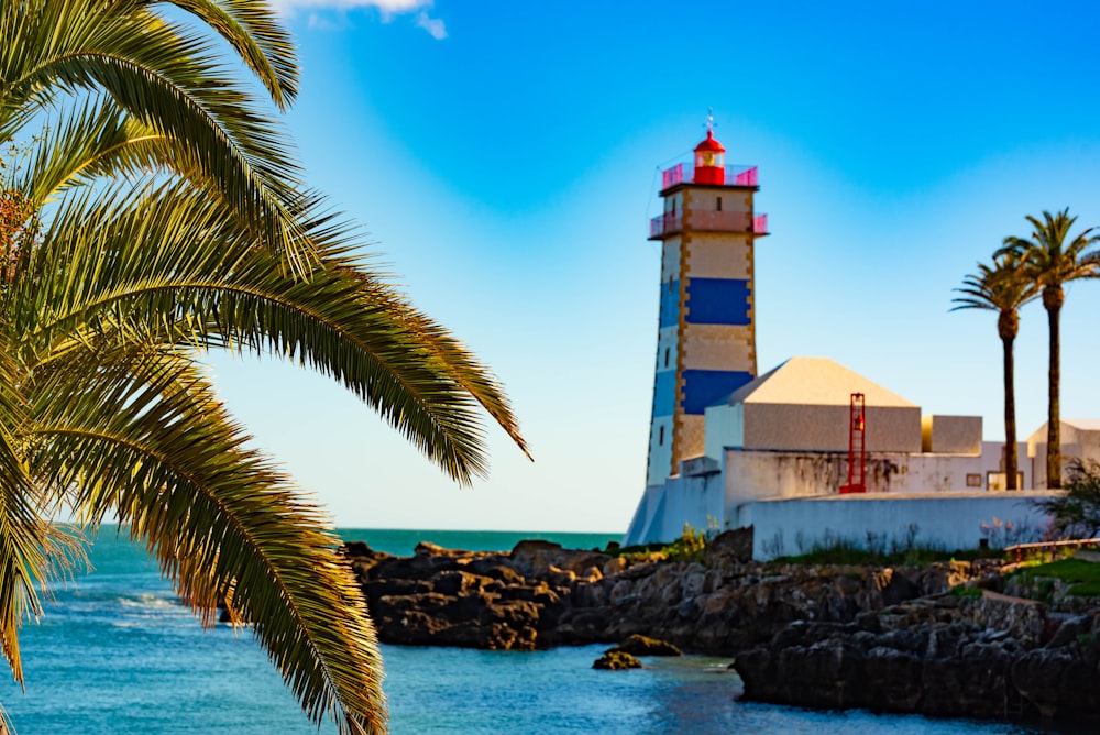 white and brown lighthouse near body of water during daytime