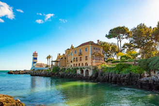 brown concrete building beside river under blue sky during daytime