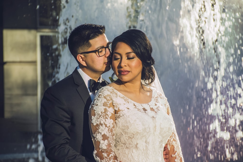 man in black suit jacket beside woman in white floral dress