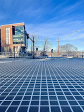 A detailed city intersection with optimized traffic signal lights under clear skies.