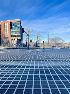 A detailed city intersection with optimized traffic signal lights under clear skies.