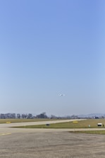 Student pilot taking off in a small training aircraft on a sunny runway.