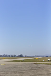 Beechcraft Baron taxiing on a runway with pilot preparing for takeoff under clear skies.