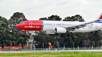 white and red passenger plane on airport during daytime