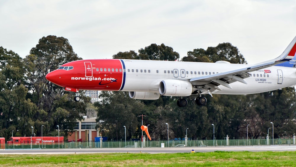 aereo passeggeri bianco e rosso sull'aeroporto durante il giorno