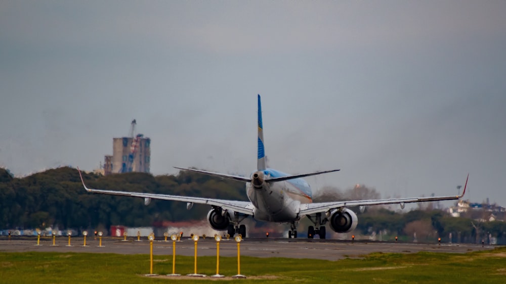 white and blue airplane on green grass field during daytime