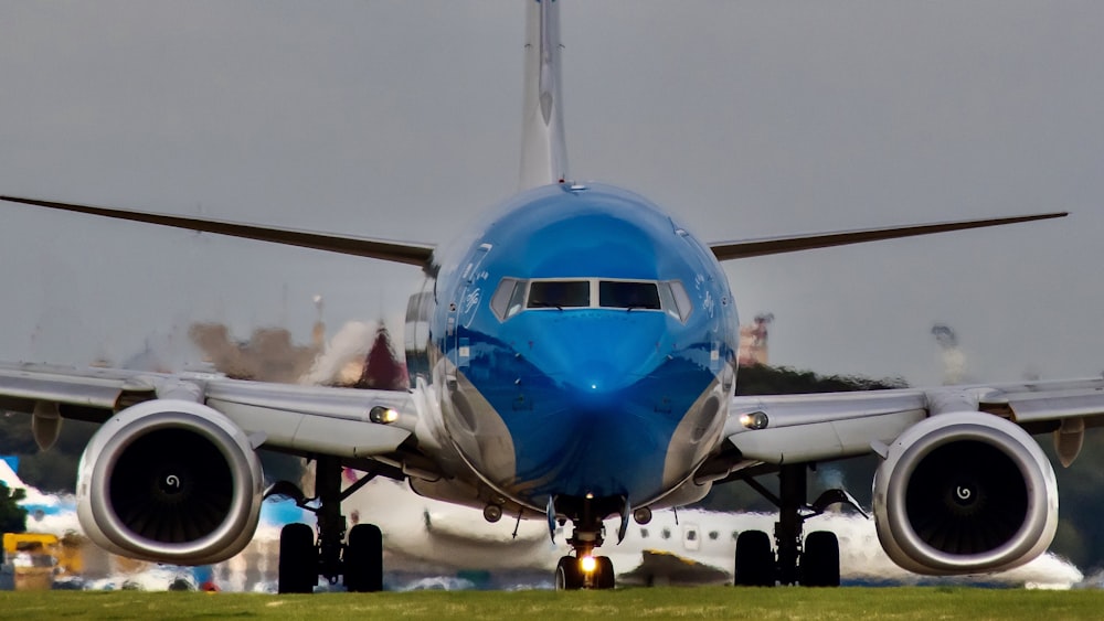 blue and white airplane on airport during daytime