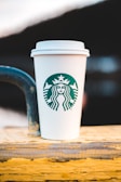 white and green starbucks cup on brown wooden table