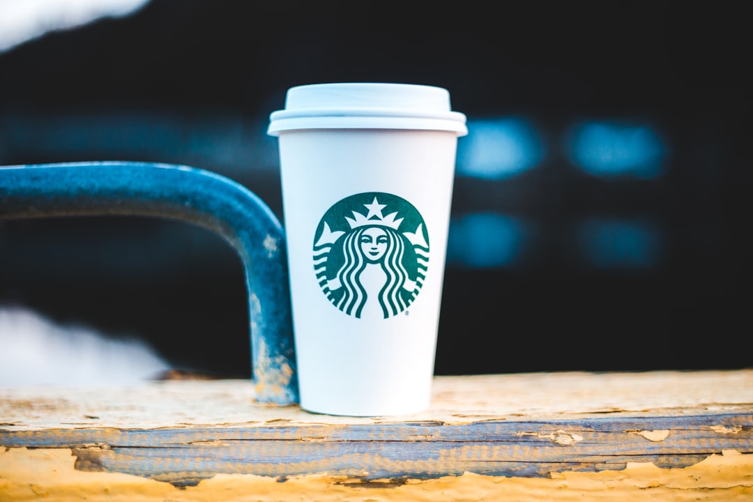 white and green starbucks cup on brown wooden table