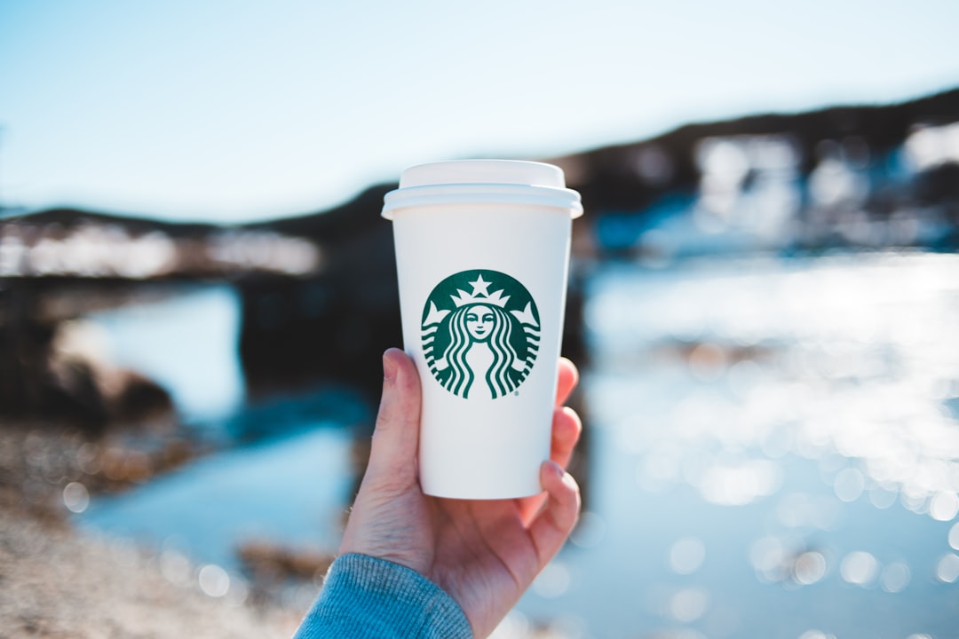 person holding white and green starbucks cup