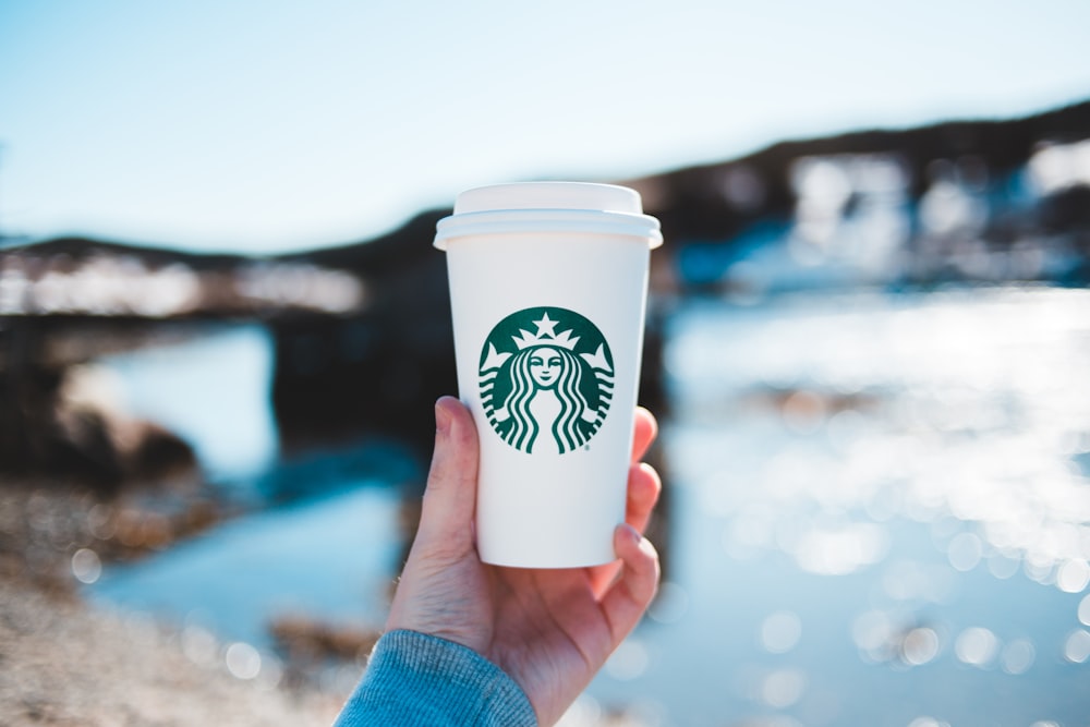 person holding white and green starbucks cup