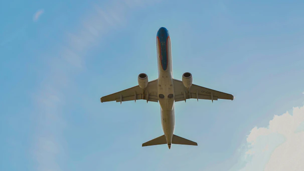 A sleek airplane soaring above a globe with a flight path tracing its route.