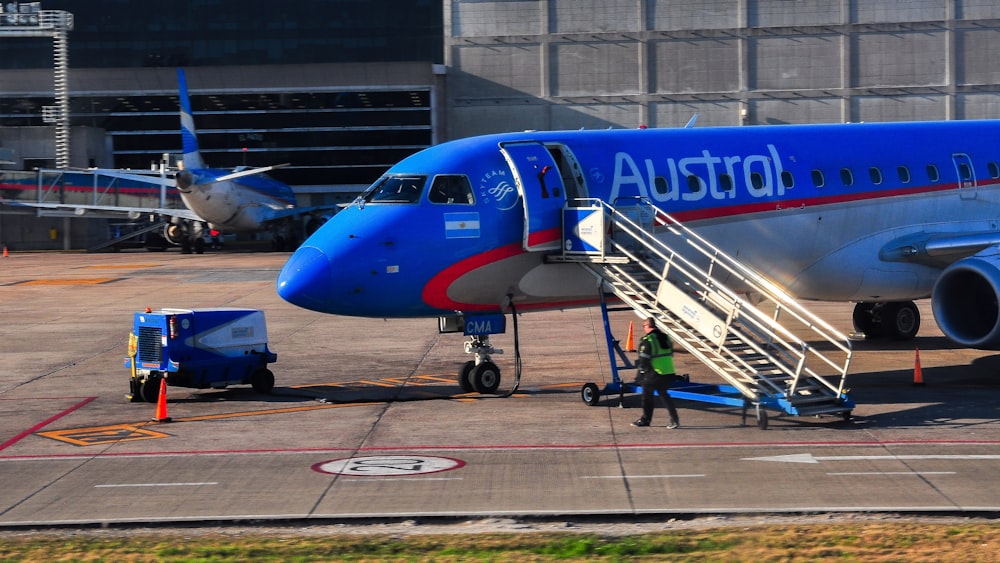 blue and white airplane on airport during daytime