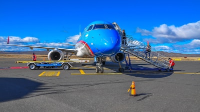 blue and white airplane on airport during daytime