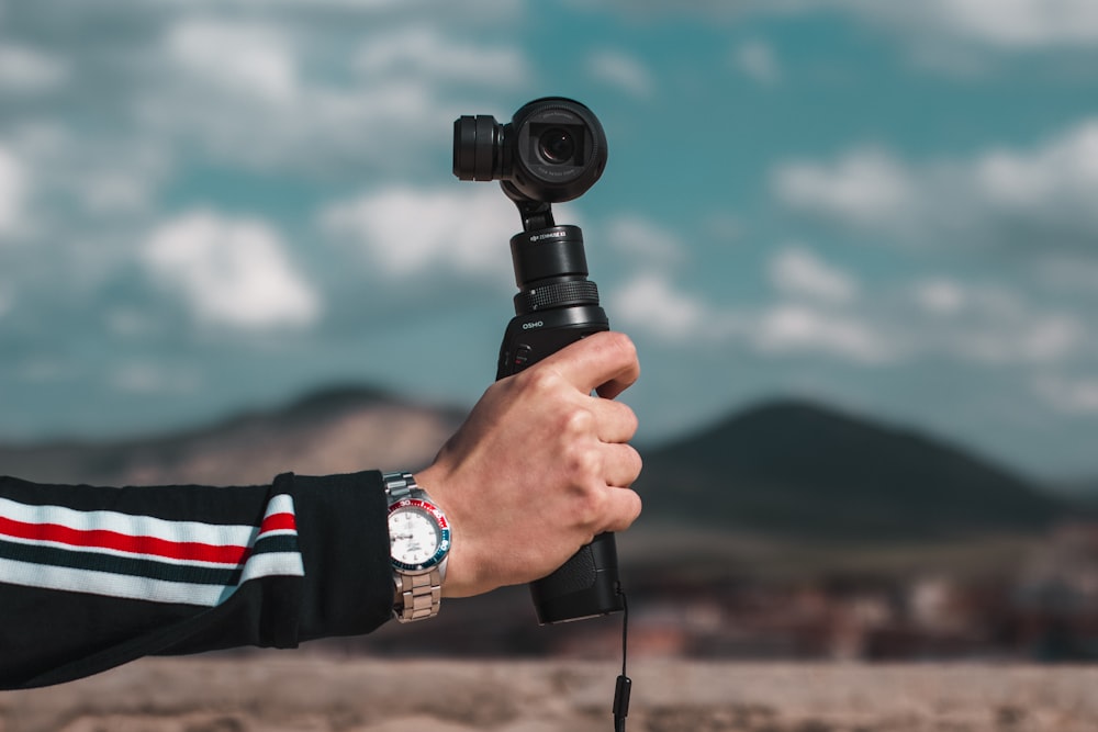 person holding black dslr camera