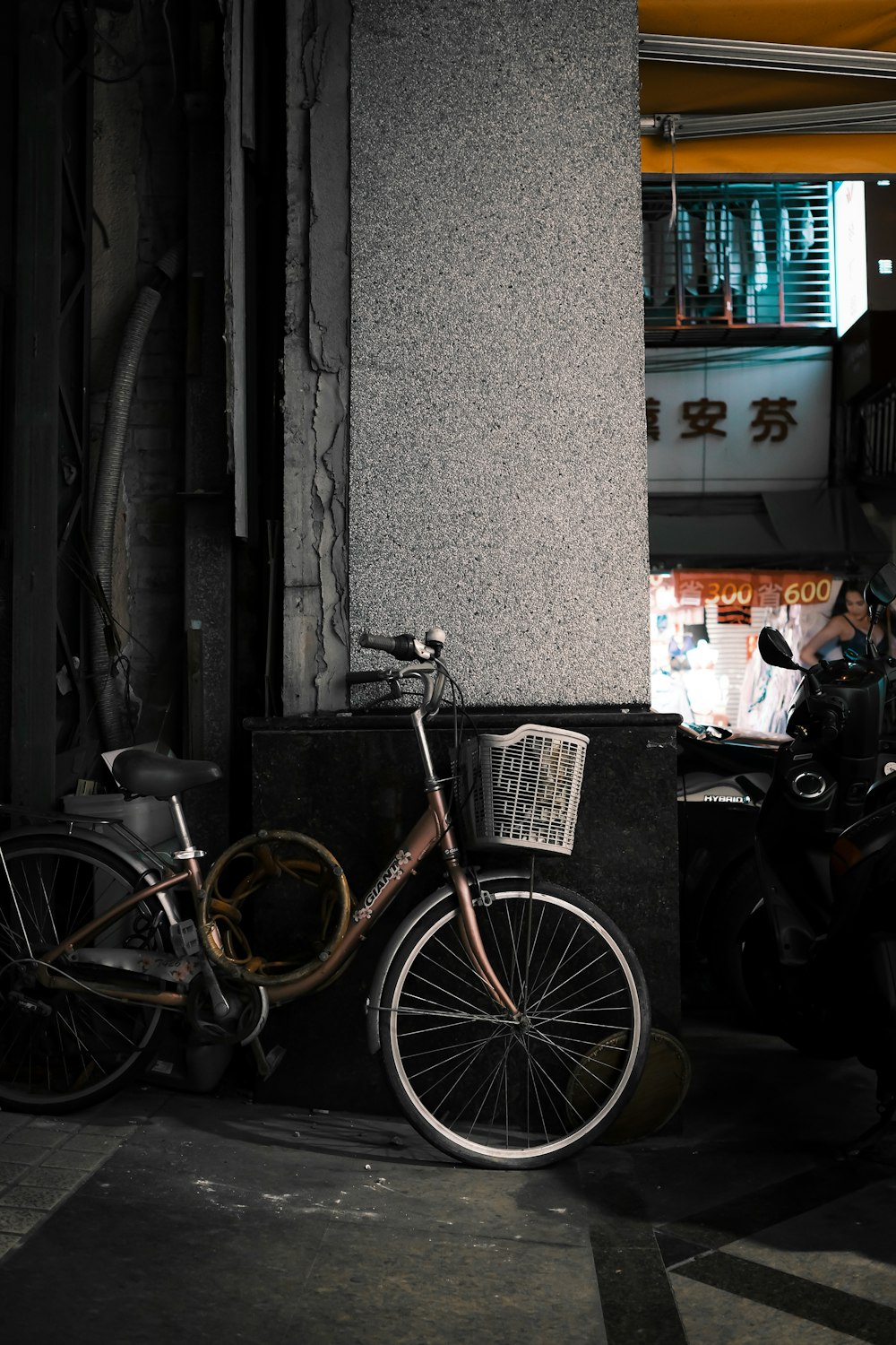 brown city bike parked beside gray concrete wall