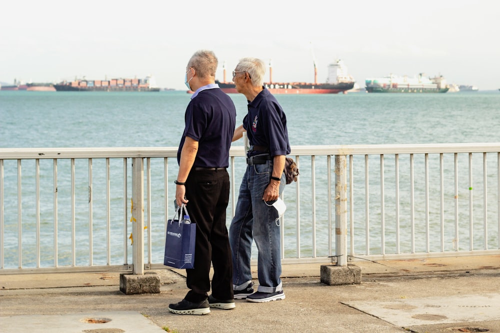 man in black t-shirt and blue denim jeans holding blue luggage bag