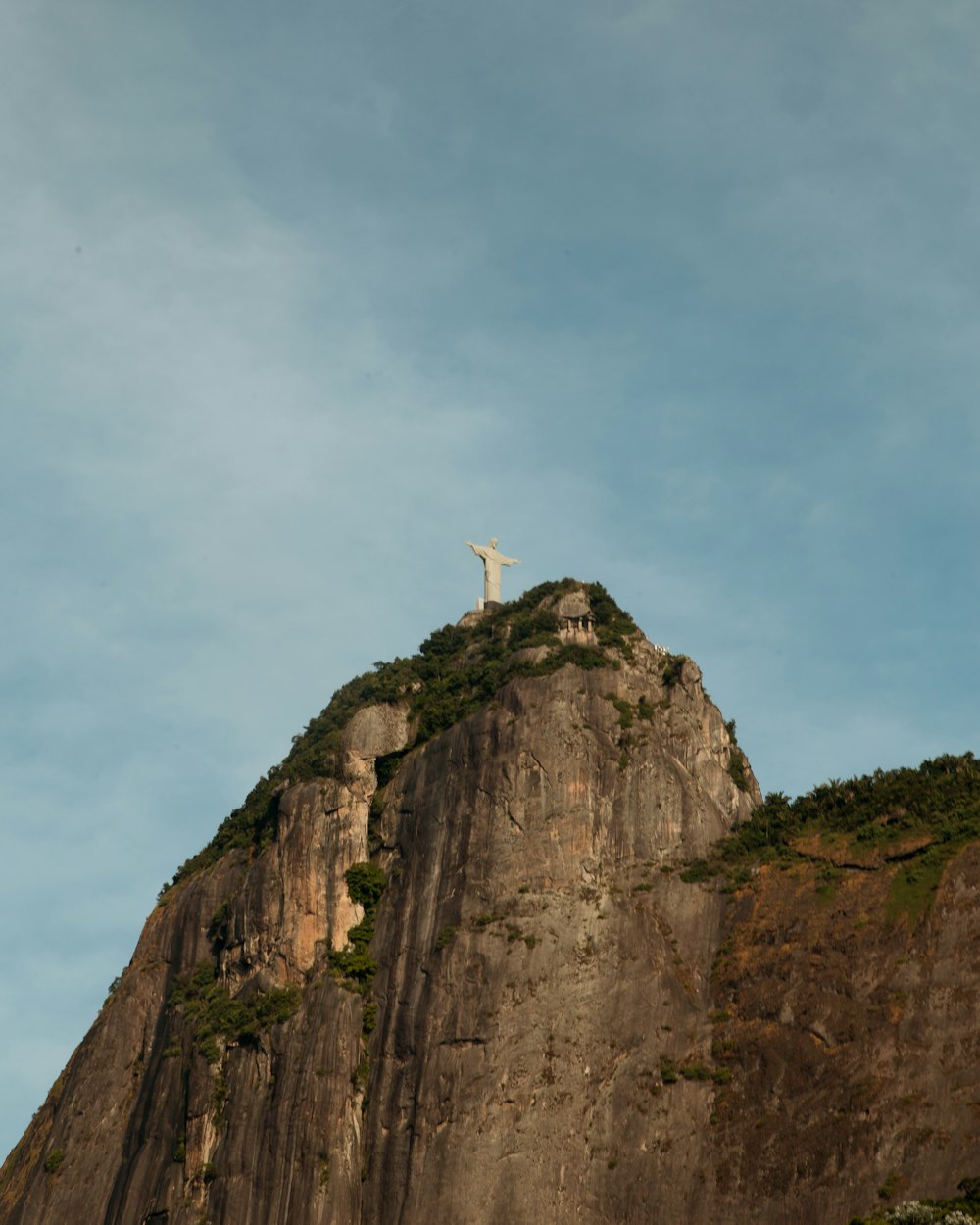 white bird on brown rock formation under white clouds during daytime