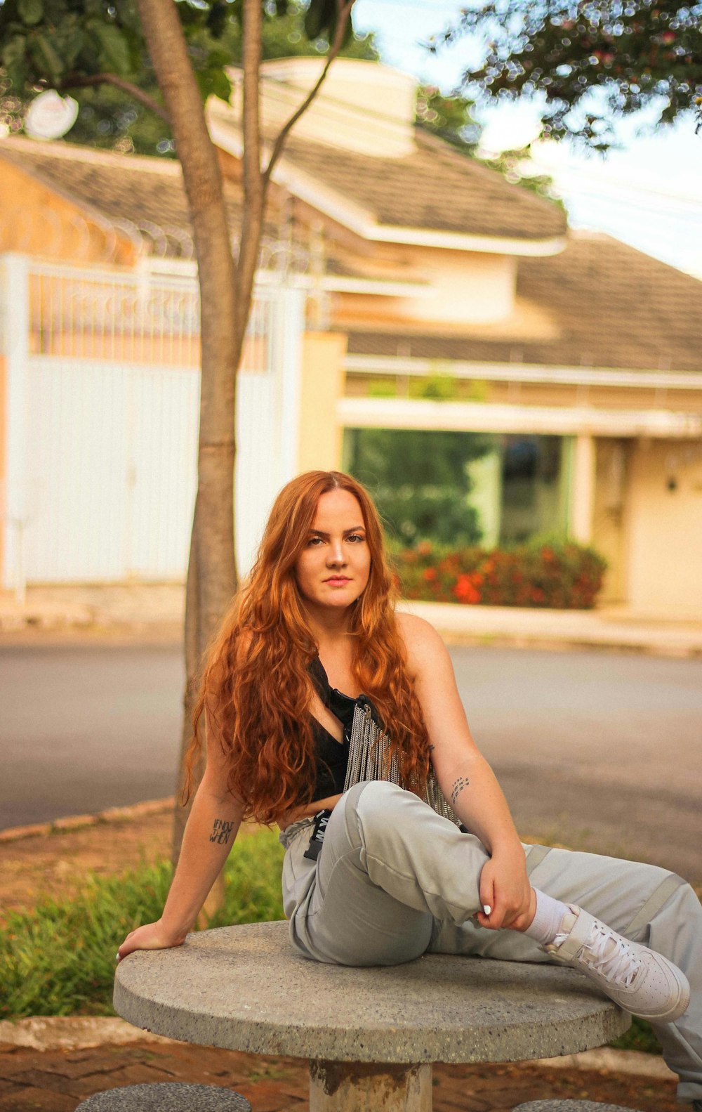 woman in black tank top sitting on gray concrete bench during daytime