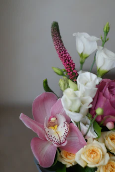 Premium floral arrangement featuring roses and orchids in soft tones
