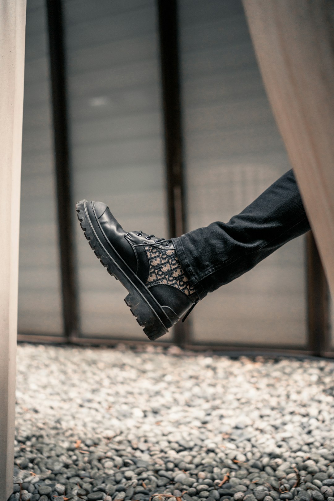 person wearing black leather lace up shoe