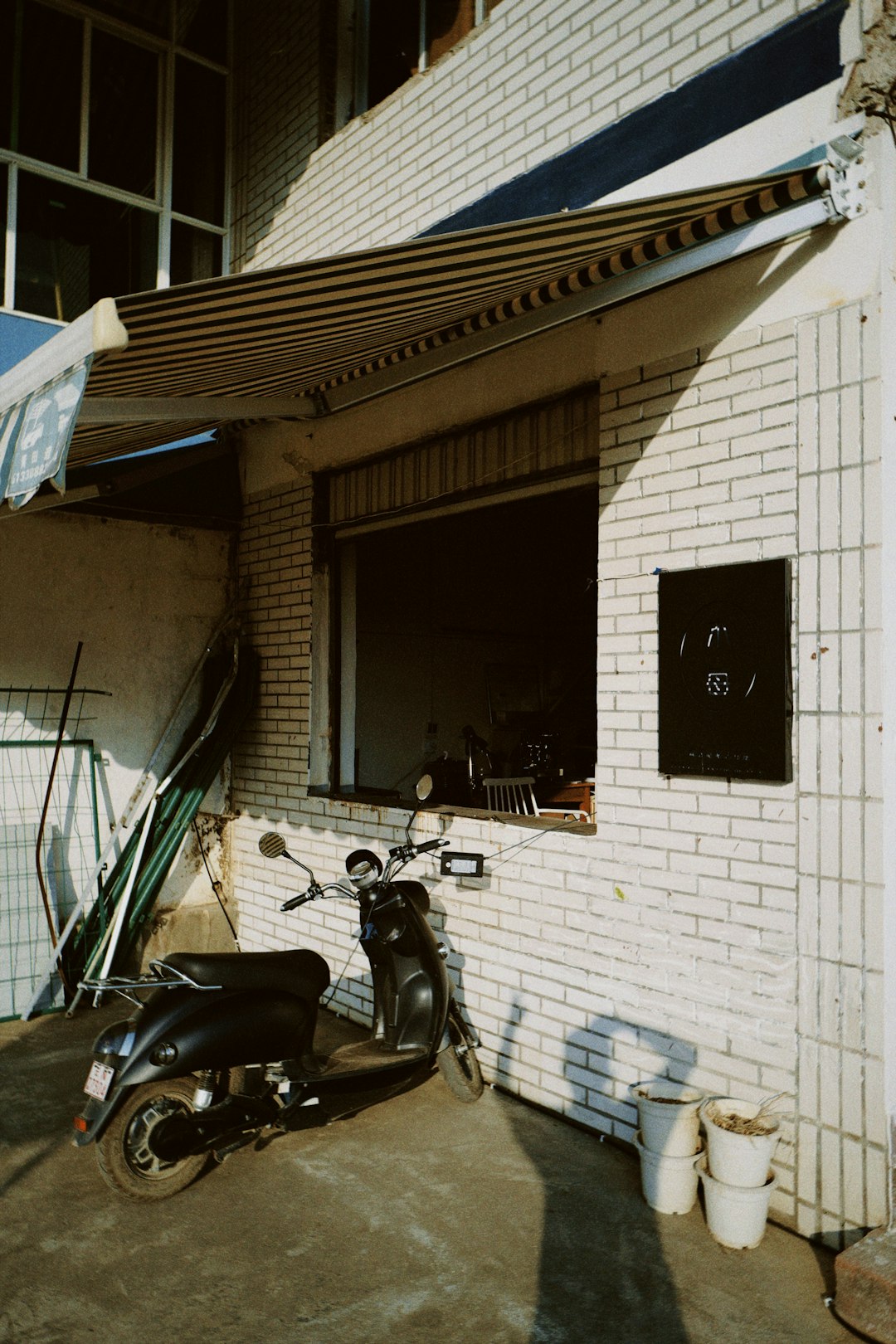 black motorcycle parked beside white concrete building