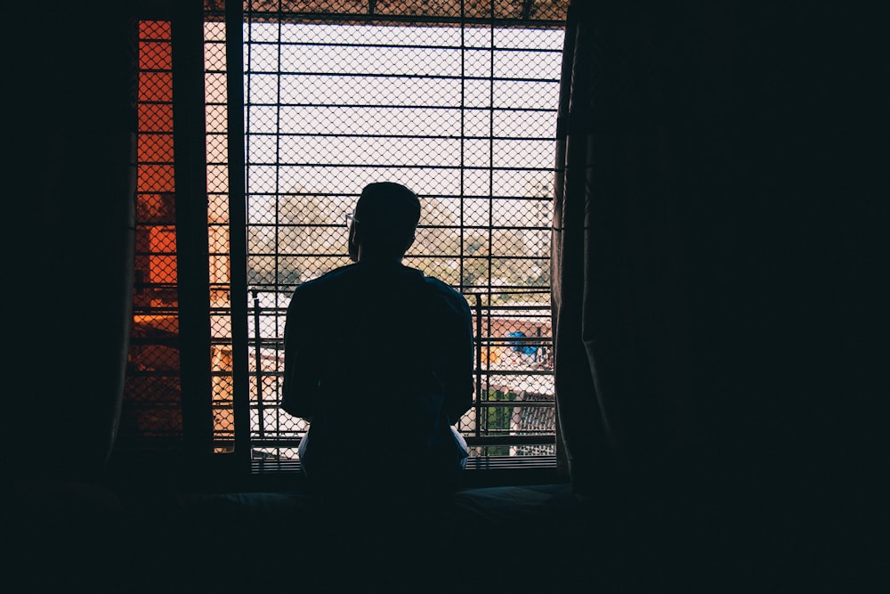 silhouette of person standing in front of window