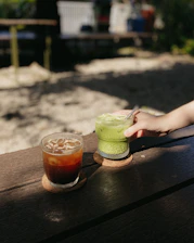 Vibrant image of colorful matcha and mocktail drinks arranged on a sleek black table.