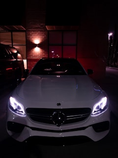 A luxurious white car with leather seats shining under city lights