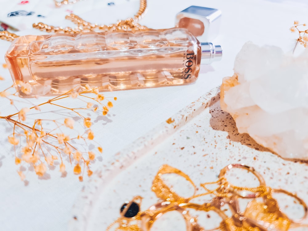 clear glass bottle on white textile