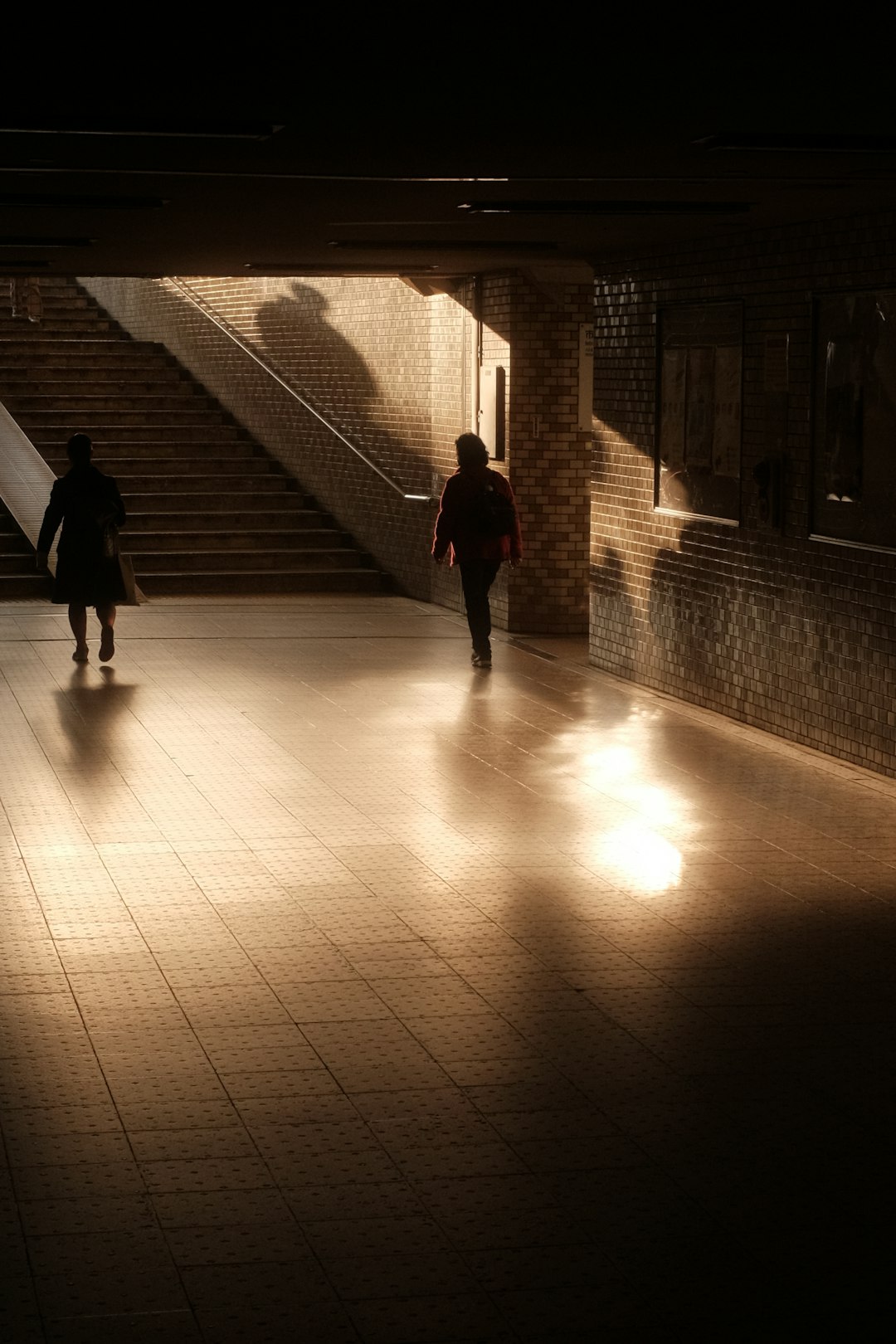 man in black jacket walking on sidewalk during daytime