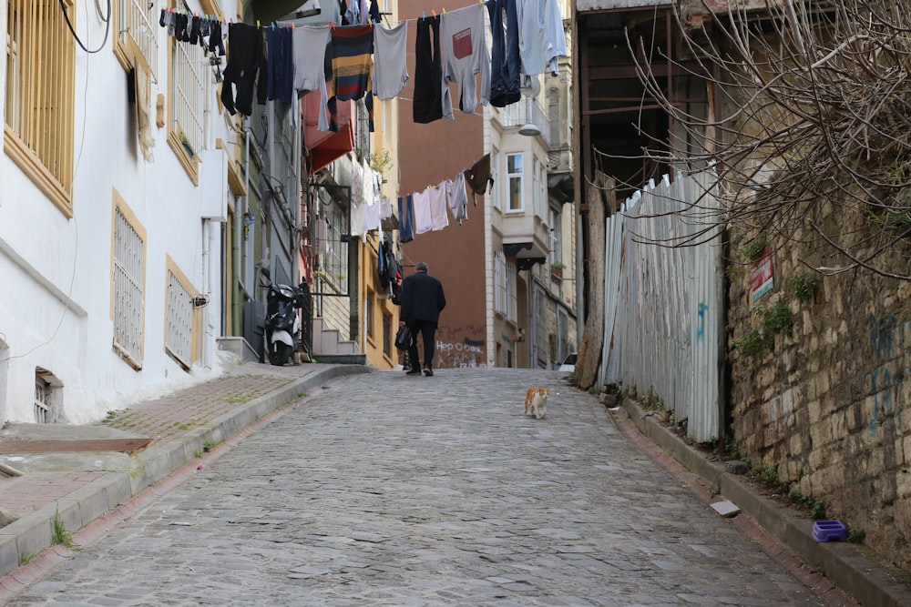 man in black jacket walking on street during daytime