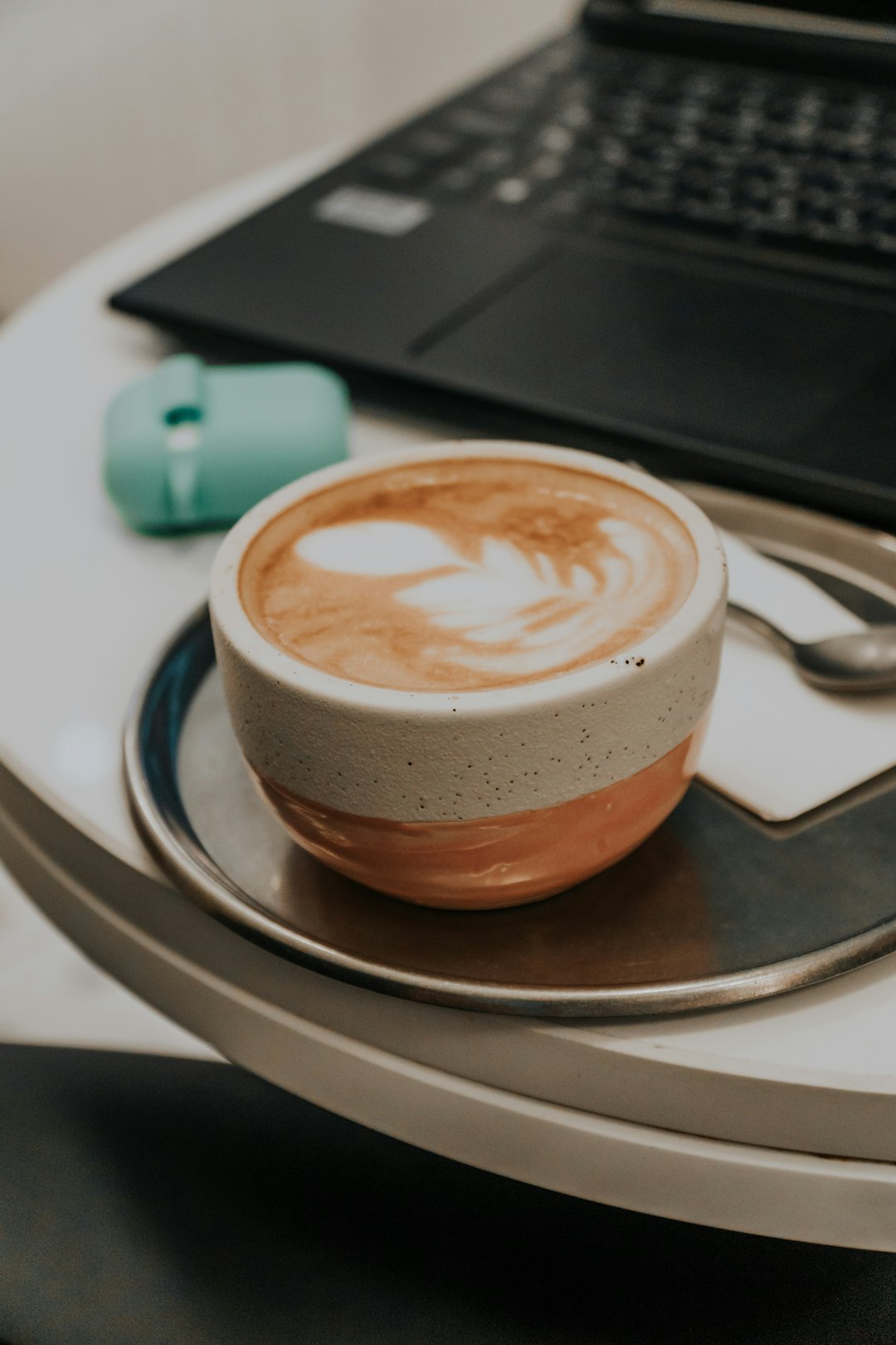 brown ceramic cup with saucer on black tray