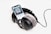 A pair of large over-ear headphones is placed around a smartphone displaying an audiobook titled 'Aum Golly'. The headphones have plush gray ear cushions and are connected with a thick black wire.